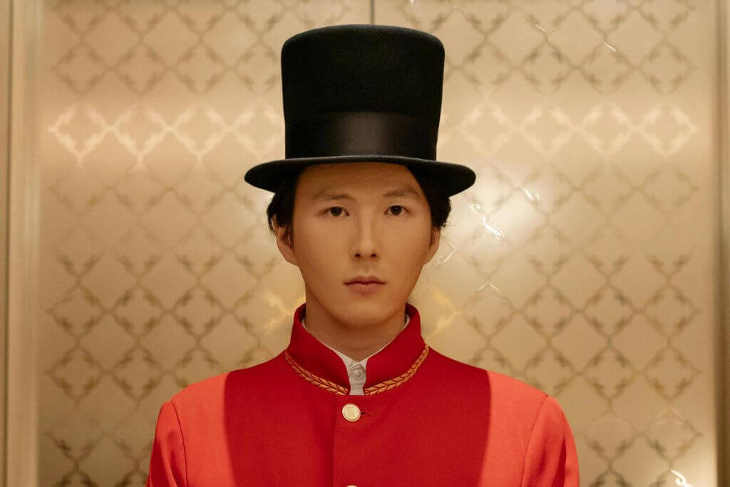 groom d'hôtel avec un chapeau et une veste rouge