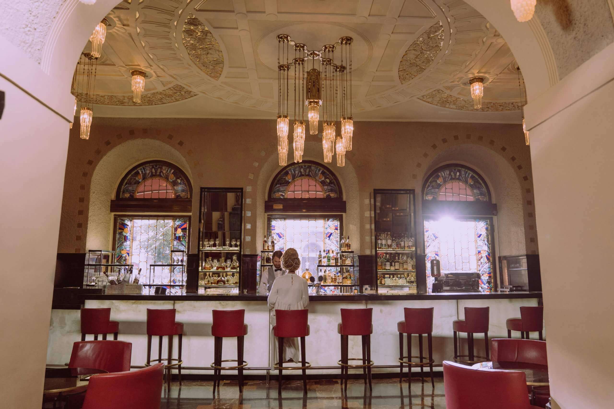 femme assise de dos au bar d'un hôtel